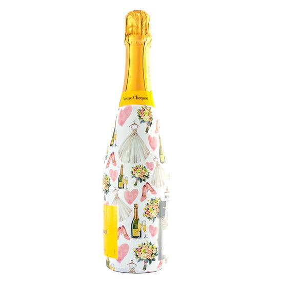 Bottle of champagne with a decorative wrap featuring wedding-themed illustrations on a white background.